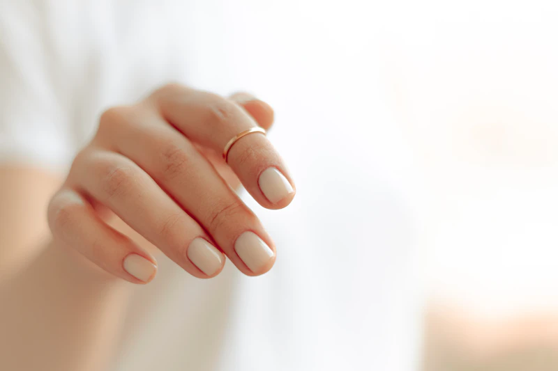 Dłonie z naturalnym manicure na białym tle