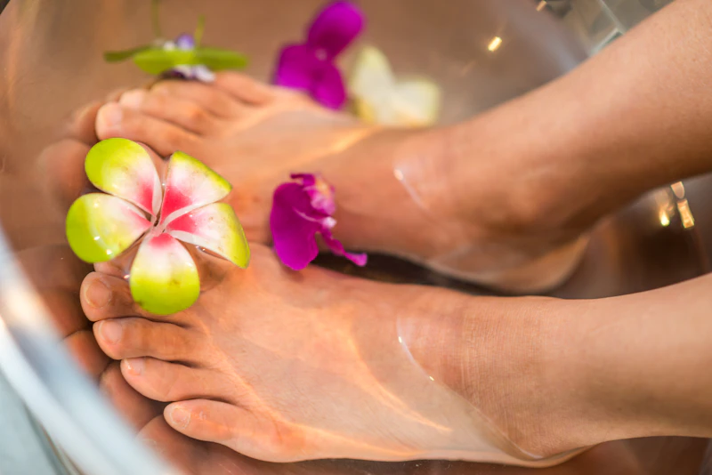 Stopy podczas pedicure w kąpieli z kwiatami
